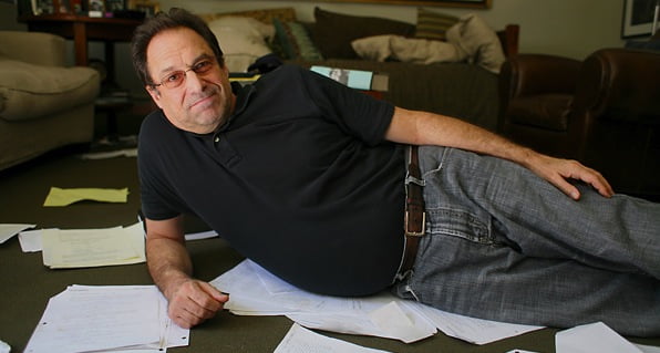 David Milch reclining amongst papers