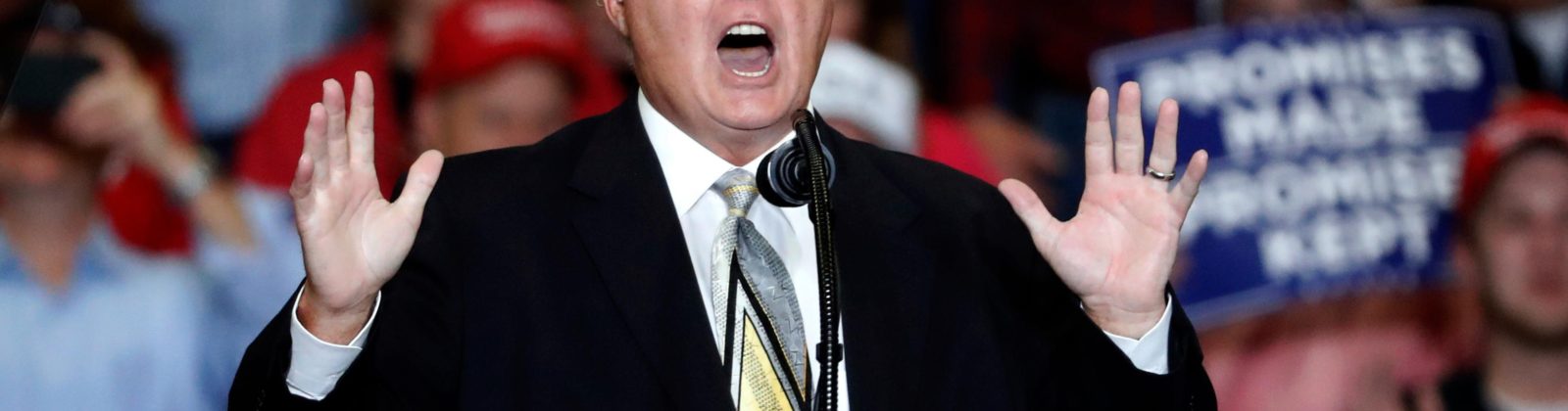 Rush Limbaugh at a podium giving a speech at a Trump campaign rally